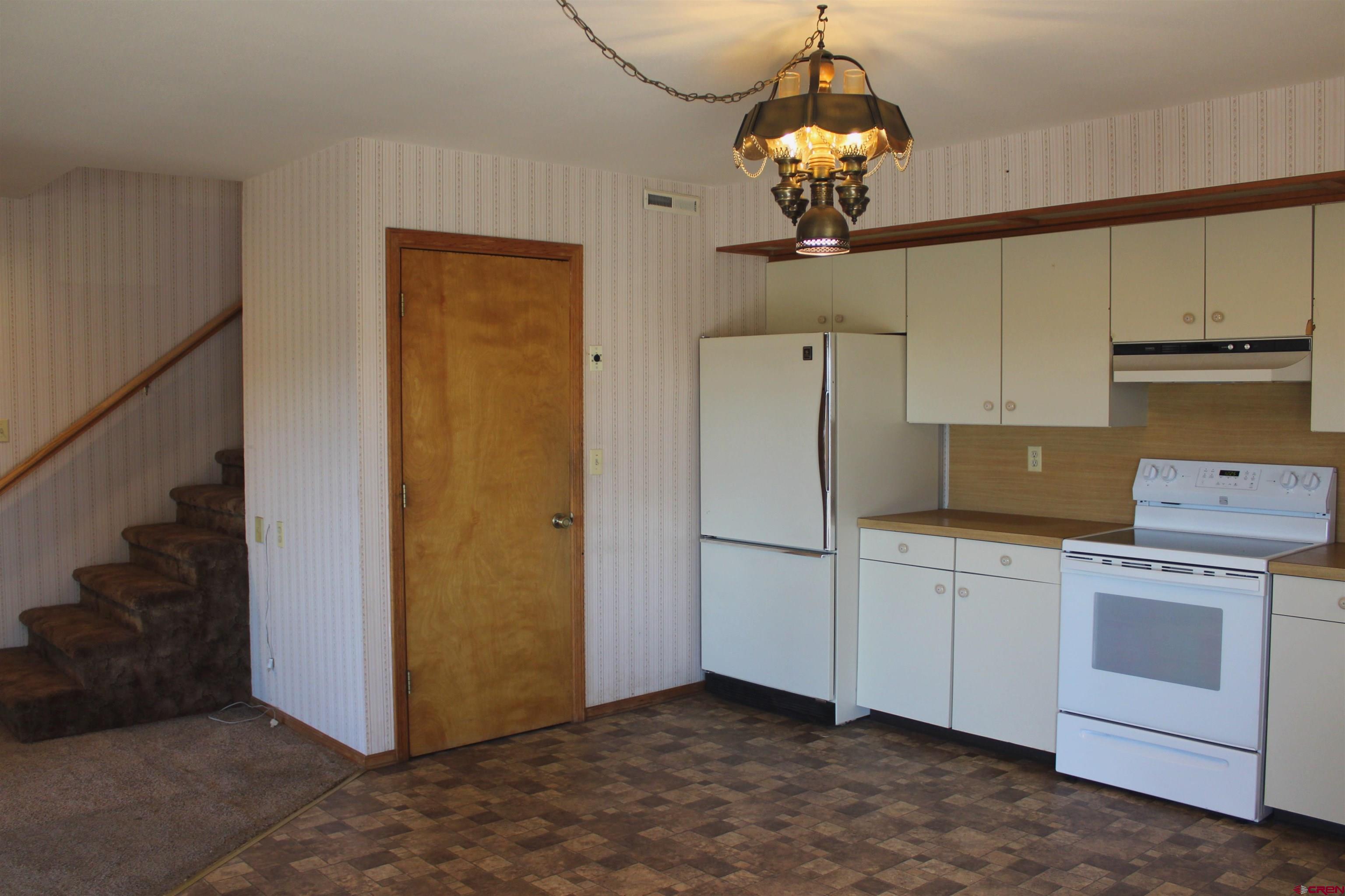 16754 Bull Mesa Road Cedaredge, CO 81413 - Photo 13 of 35 a kitchen that has a stainless steel appliances granite countertop cabinets and a chandelier