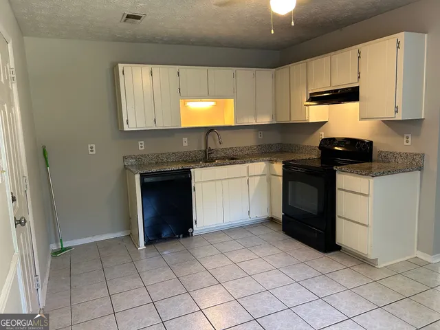 a kitchen with a sink and a stove top oven