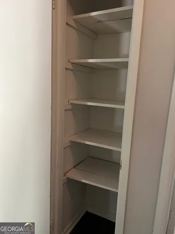 a view of walk in closet with empty racks
