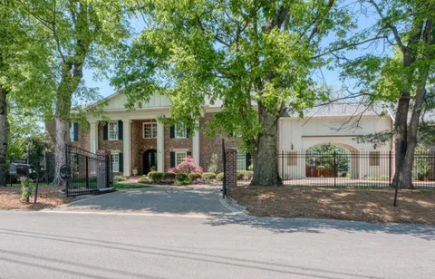 a view of a house with a tree in front of it