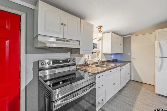 a kitchen with granite countertop a stove and a refrigerator