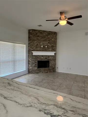 a view of empty room with wooden floor and a fireplace