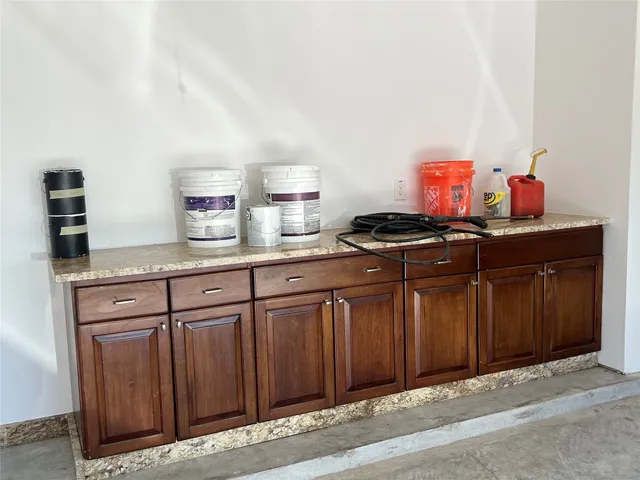 a kitchen with granite countertop a sink cabinets and stainless steel appliances