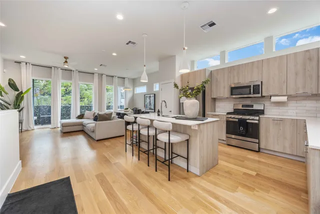 a large white kitchen with a large window and stainless steel appliances