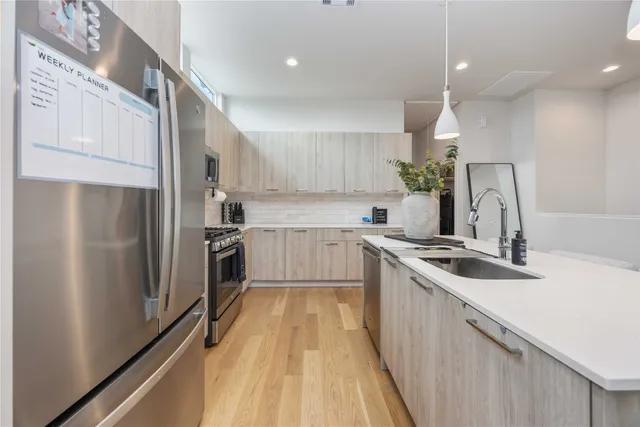 a kitchen with stainless steel appliances granite countertop a sink stove and refrigerator