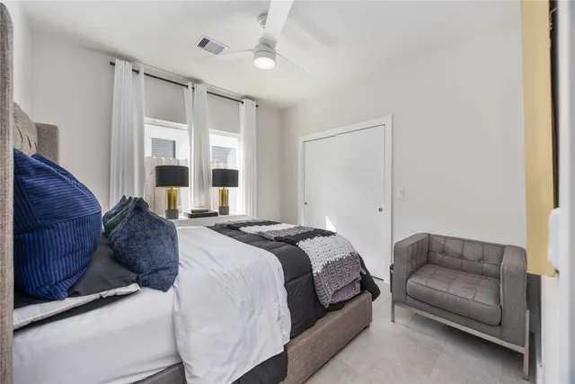 a spacious bedroom with a bed couch and window