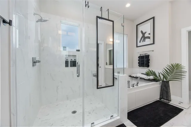 a bathroom with a bathtub shower sink and mirror