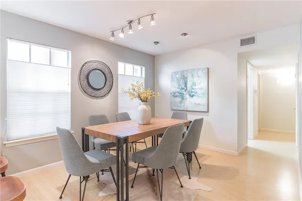 an empty room with wooden floor chandelier fan and windows