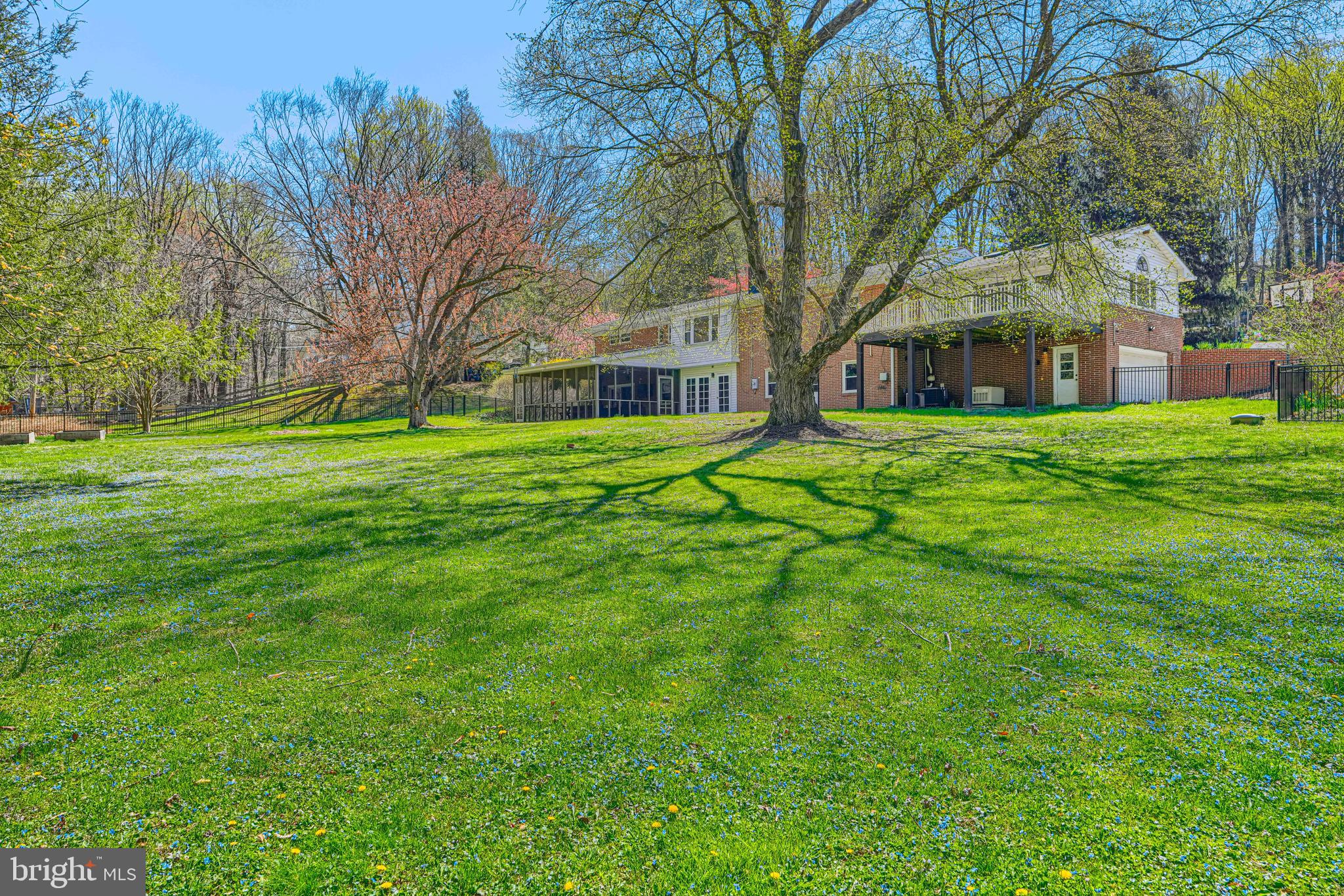 802 Stone Barn Road Towson, MD 21286 - Photo 100 of 104 a brick house next to a yard with large trees