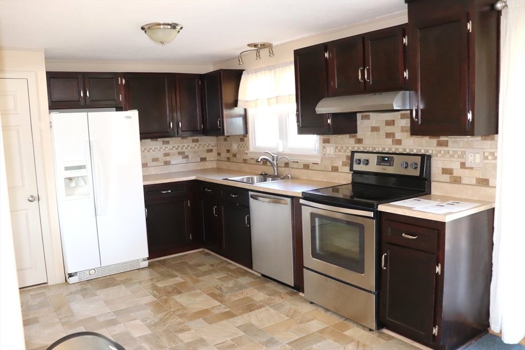 75 Garrison Road Chelmsford, MA 01824 - Photo 10 of 28 a kitchen with a sink stove and cabinets