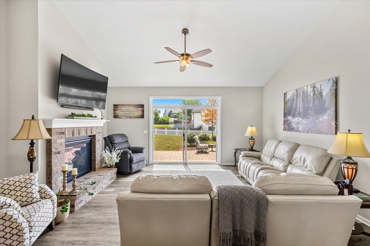 2220 Tyler Trail McHenry, IL 60051 - Photo 6 of 24 a living room with furniture a flat screen tv and a fireplace