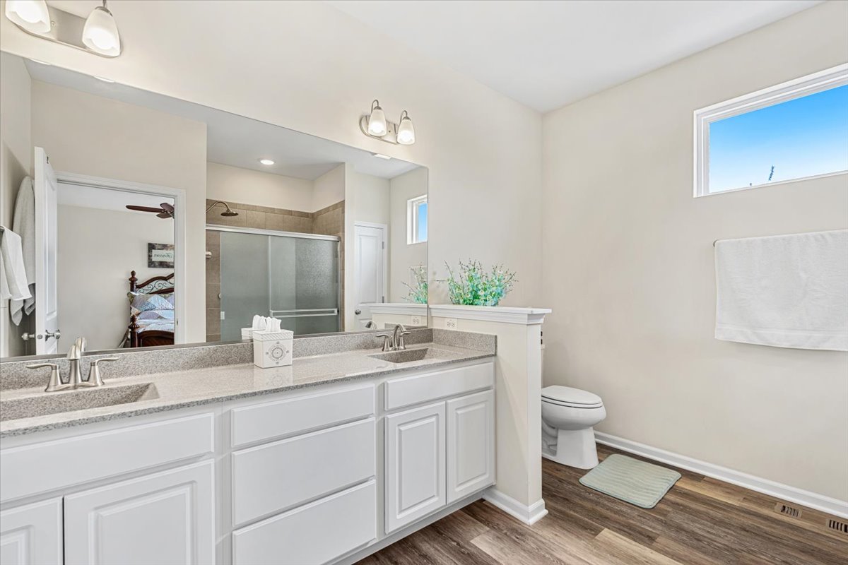 2220 Tyler Trail McHenry, IL 60051 - Photo 10 of 24 a bathroom with a granite countertop sink a toilet and a mirror