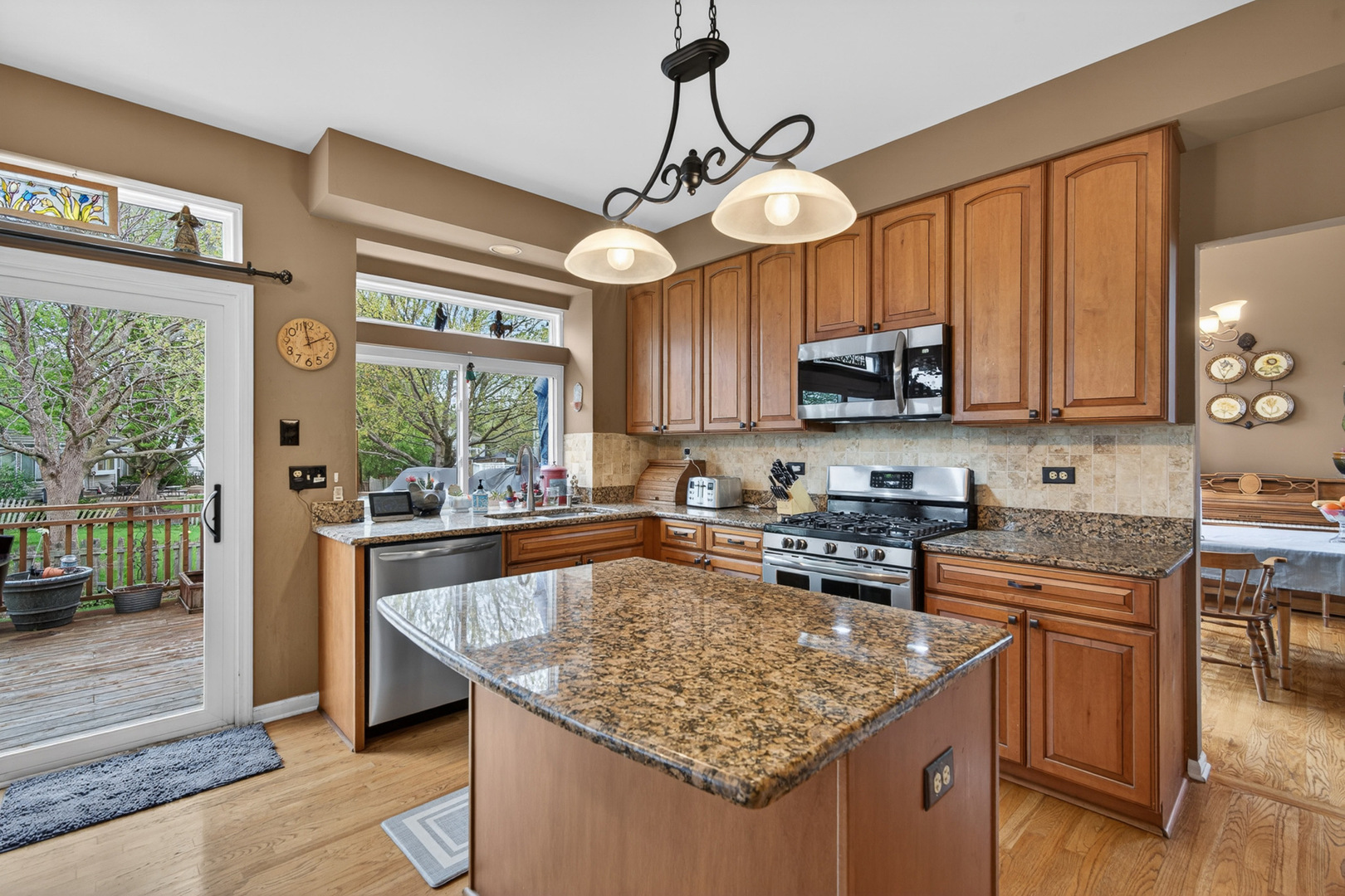 1160 Heavens Gate Lake In The Hills, IL 60156 - Photo 17 of 49 a kitchen with stainless steel appliances granite countertop a sink a stove and a wooden cabinets