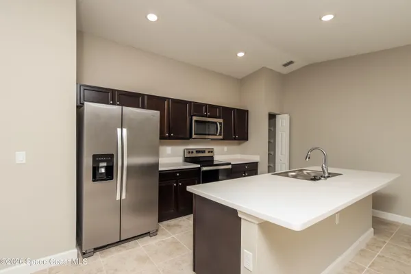 a kitchen with stainless steel appliances a refrigerator a sink a stove a microwave and island