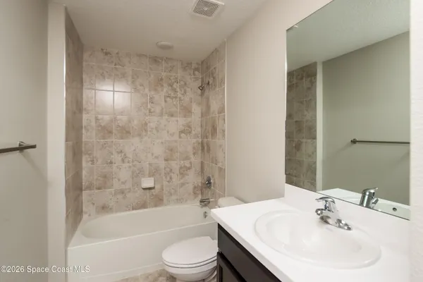 a bathroom with a bathtub shower sink vanity and toilet