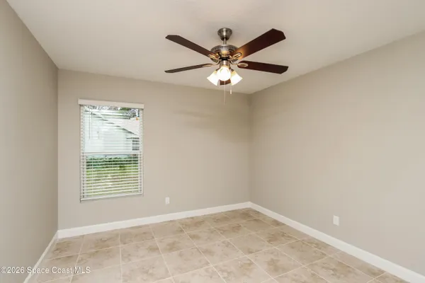 an empty room with windows and fan