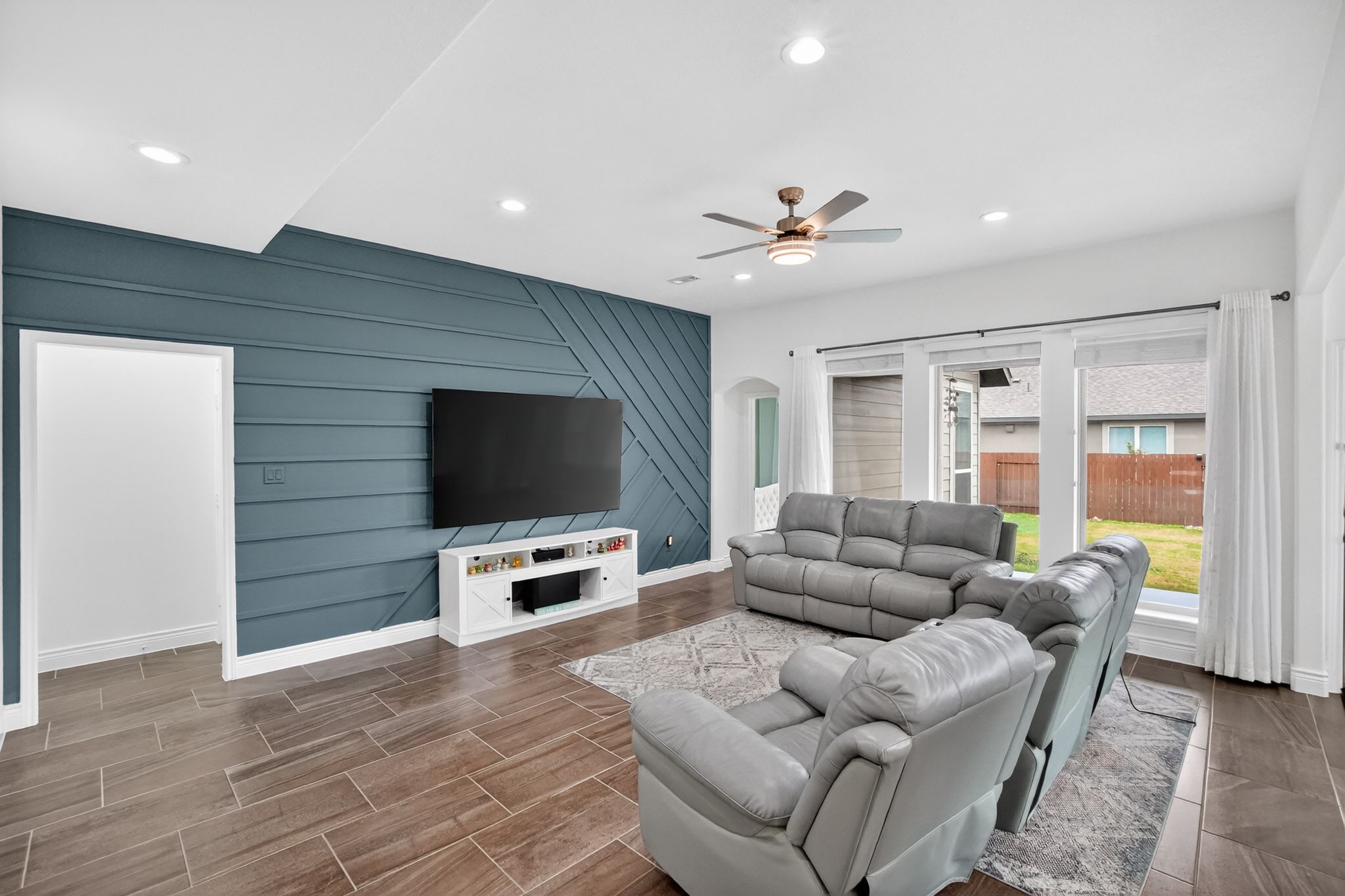 400 Cortona Lane Georgetown, TX 78628 - Photo 11 of 40 Living area featuring an accent wall, wood finish floors, arched walkways, ceiling fan, and recessed lighting