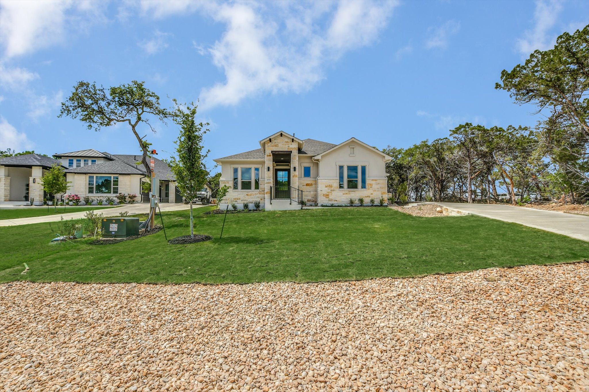 a front view of a house with a yard and trees
