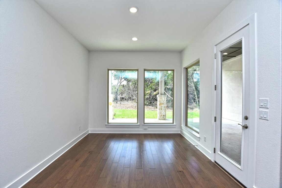 4828 Destination Way Jonestown, TX 78645 - Photo 12 of 33 a view of an empty room with wooden floor and a window