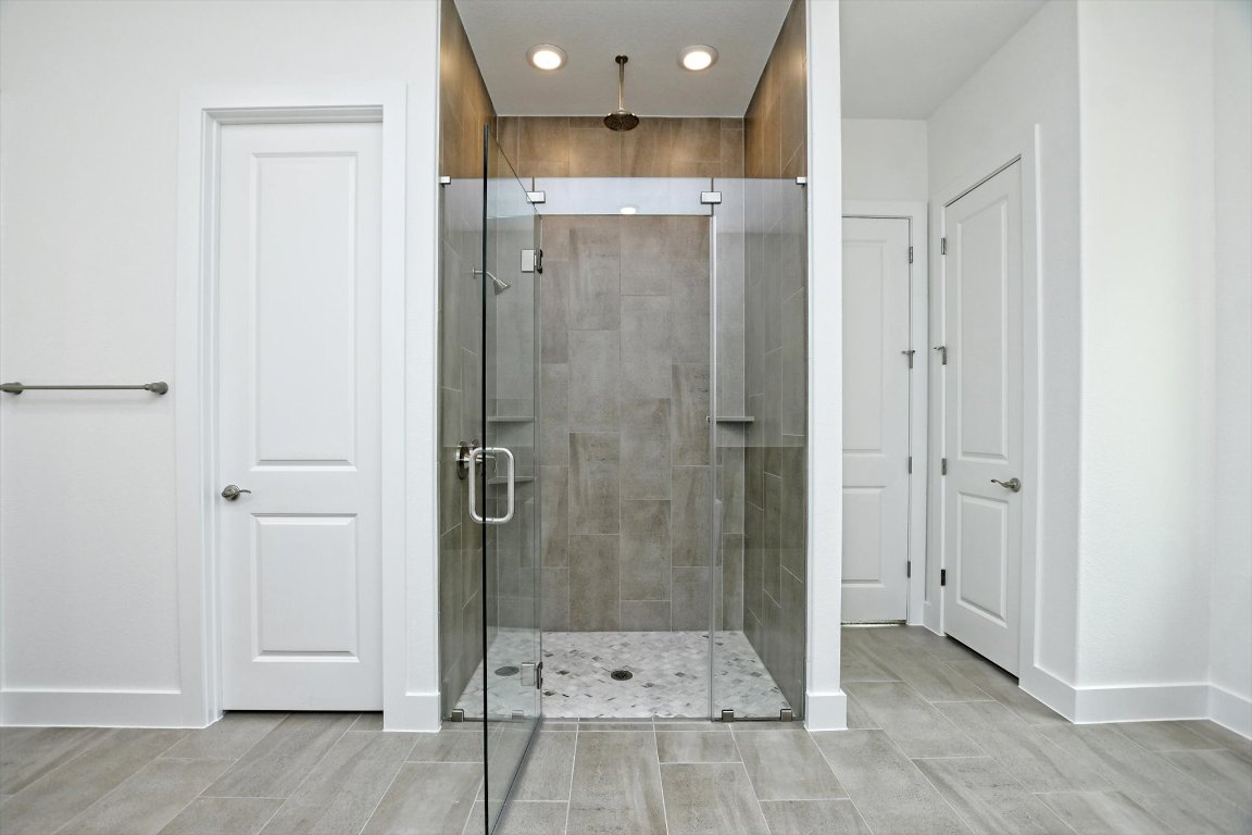 4828 Destination Way Jonestown, TX 78645 - Photo 18 of 33 a bathroom with a glass shower door