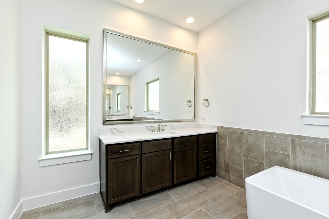 4828 Destination Way Jonestown, TX 78645 - Photo 20 of 33 a bathroom with a sink mirror and a bathtub