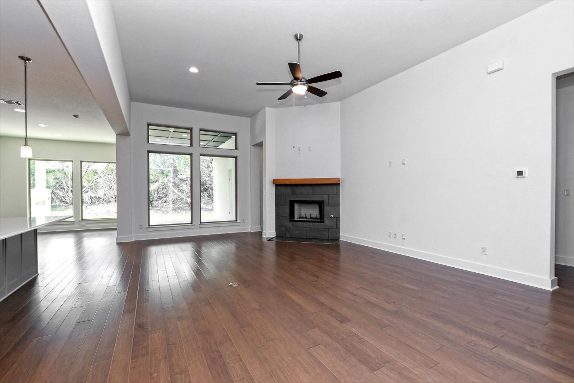 4828 Destination Way Jonestown, TX 78645 - Photo 8 of 33 an empty room with wooden floor chandelier and windows