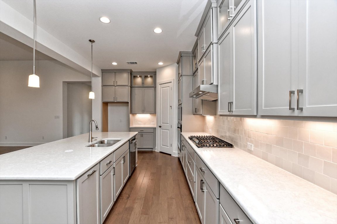 4828 Destination Way Jonestown, TX 78645 - Photo 10 of 33 a kitchen with a sink stove and cabinets