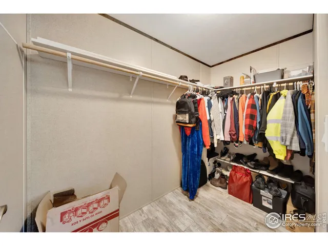 a view of walk in closet with clothes and shoes