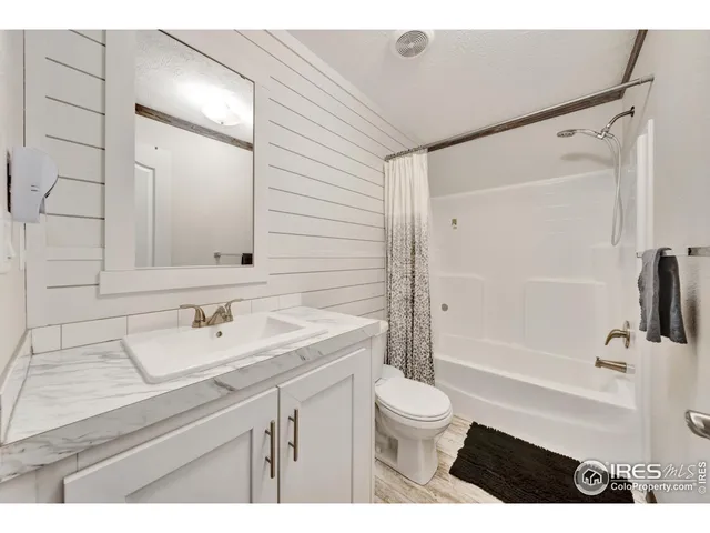 a bathroom with a sink a toilet a mirror and shower
