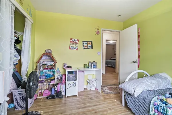 a bedroom with a bed and a wooden floor