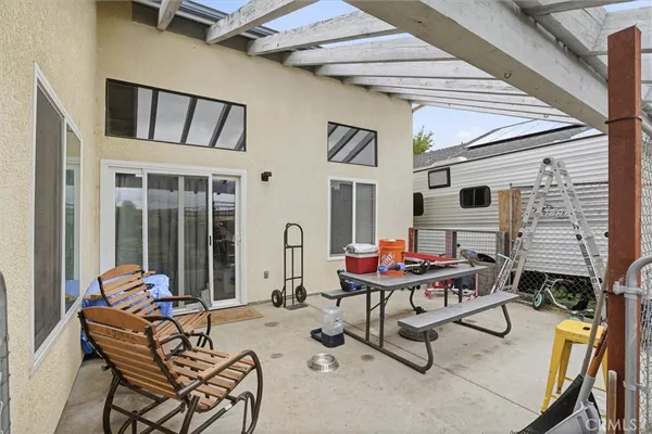 a backyard of a house with barbeque oven table and chairs