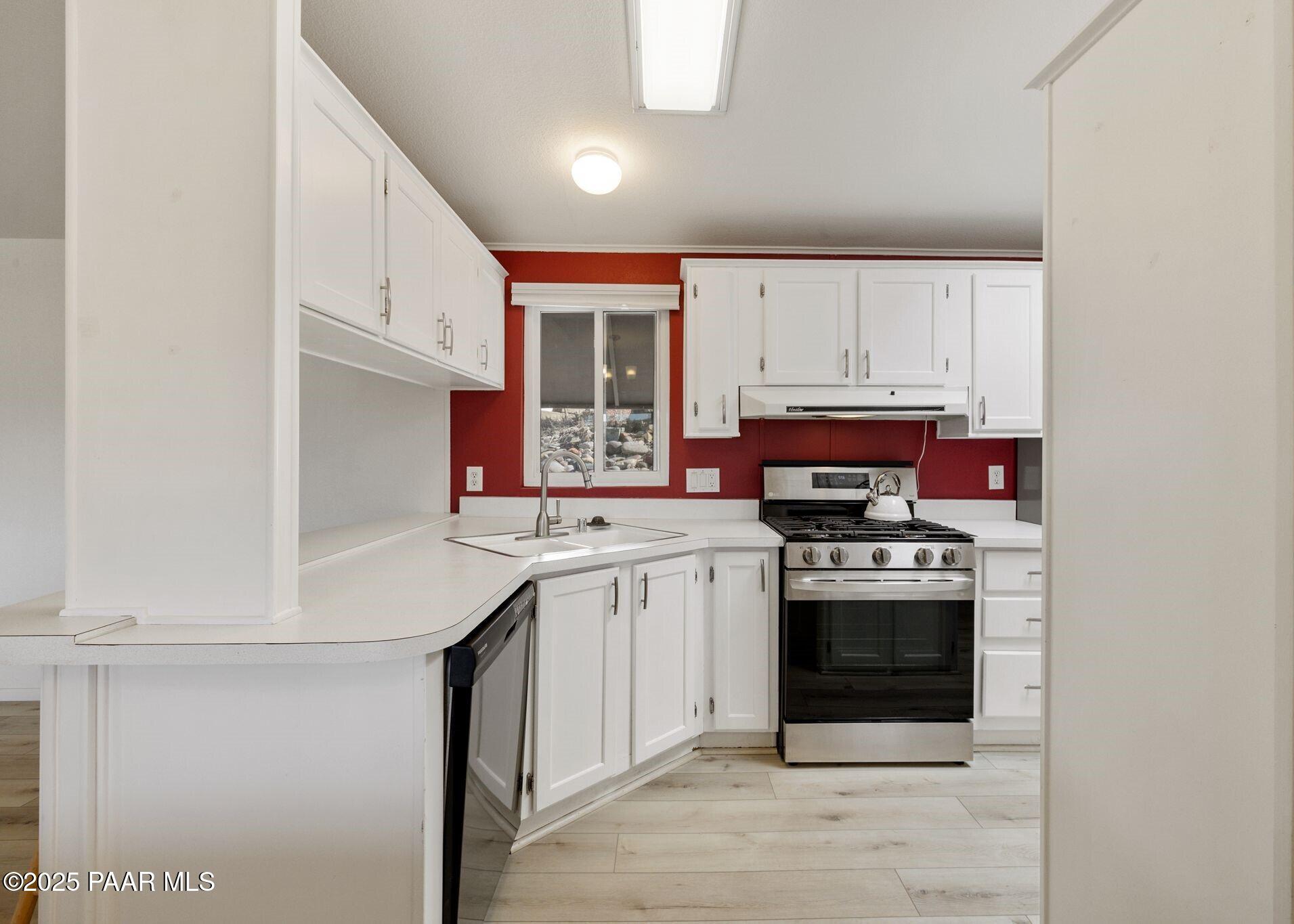 2572 Hilltop Road Prescott, AZ 86301 - Photo 19 of 34 a kitchen with stainless steel appliances granite countertop a stove a sink and a microwave