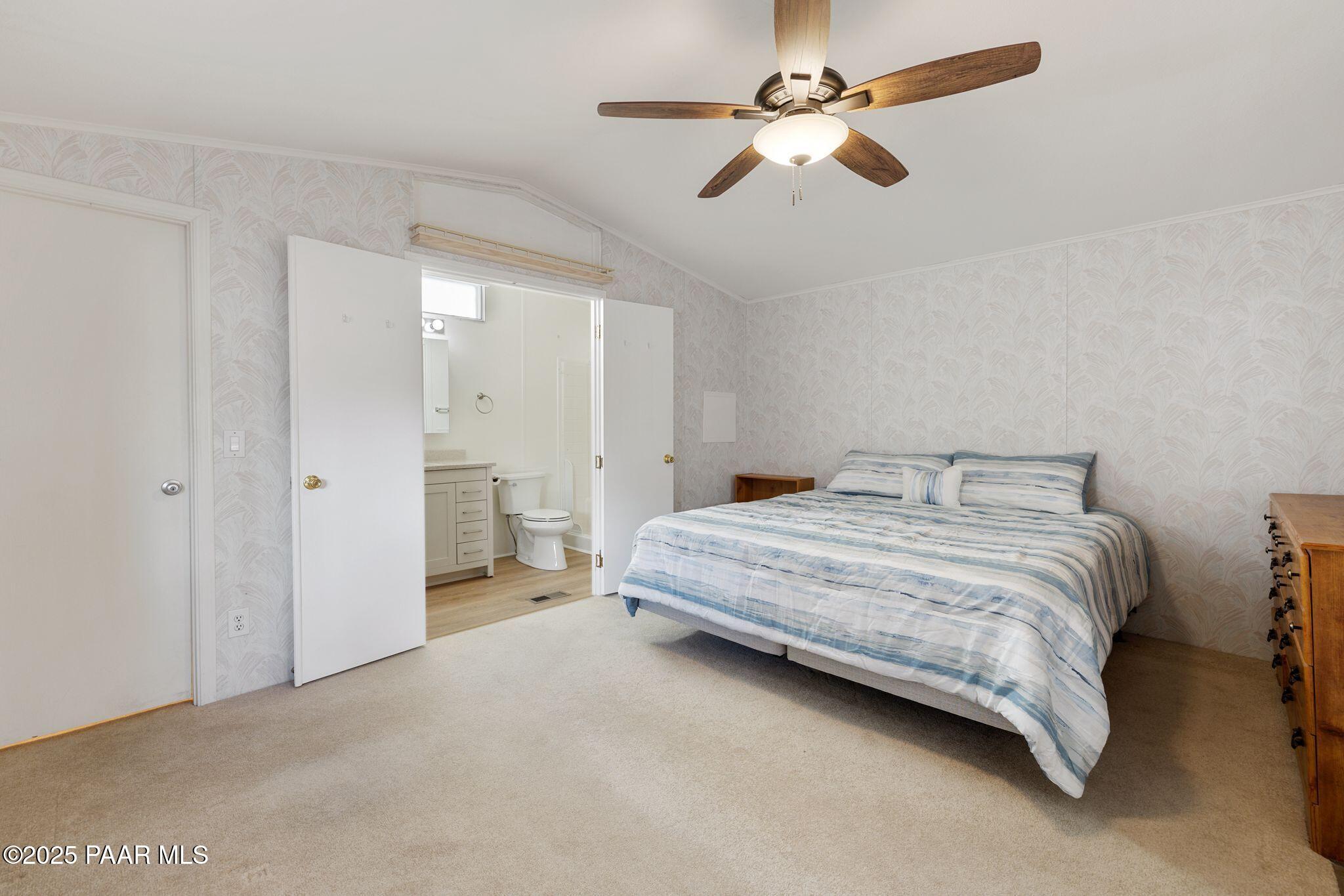 2572 Hilltop Road Prescott, AZ 86301 - Photo 25 of 34 a spacious bedroom with a bed and a ceiling fan