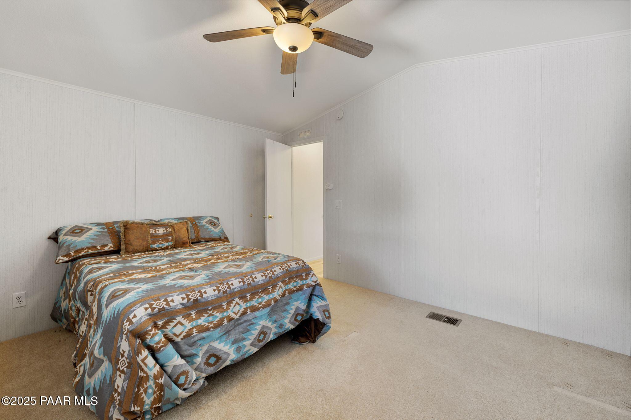 2572 Hilltop Road Prescott, AZ 86301 - Photo 32 of 34 a bedroom with a bed and a chandelier fan