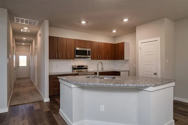 a kitchen with stainless steel appliances granite countertop a sink stove microwave and cabinets