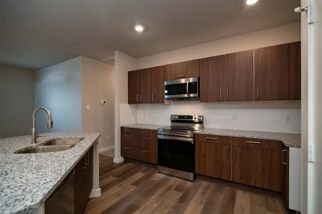 a kitchen with stainless steel appliances granite countertop a sink stove and refrigerator