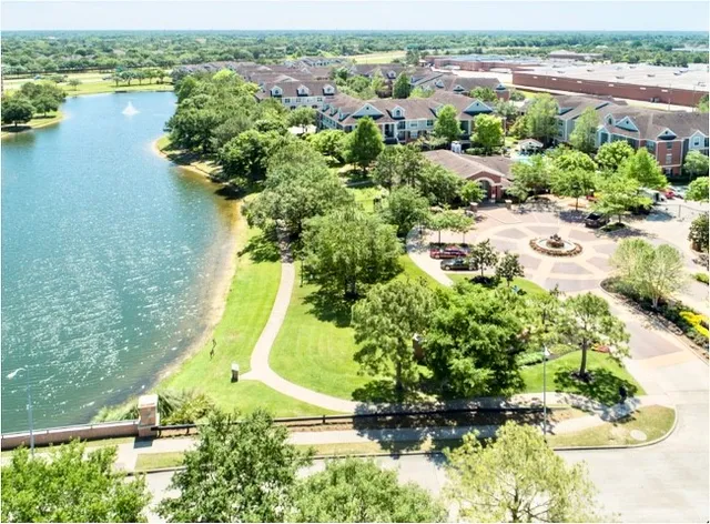 a bench sitting in the middle of a park with large trees