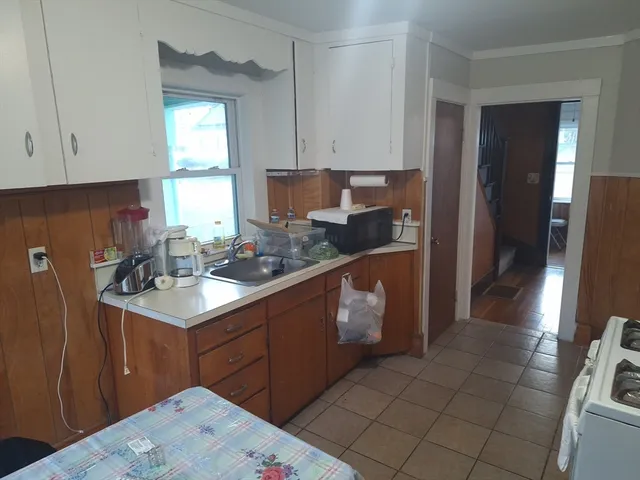 a kitchen with a sink a refrigerator and cabinets