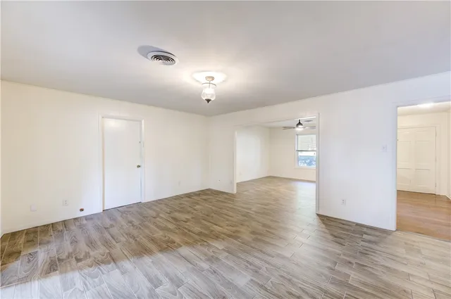 a view of empty room with wooden floor