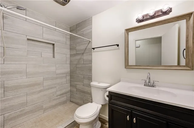 a bathroom with a sink a toilet and shower