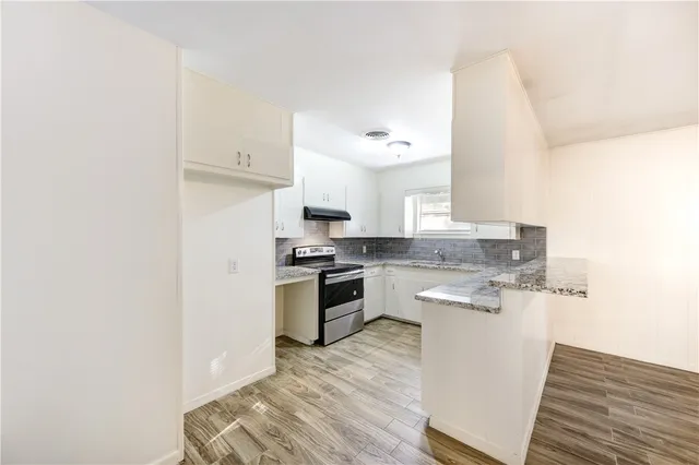 a kitchen with a sink cabinets and wooden floor