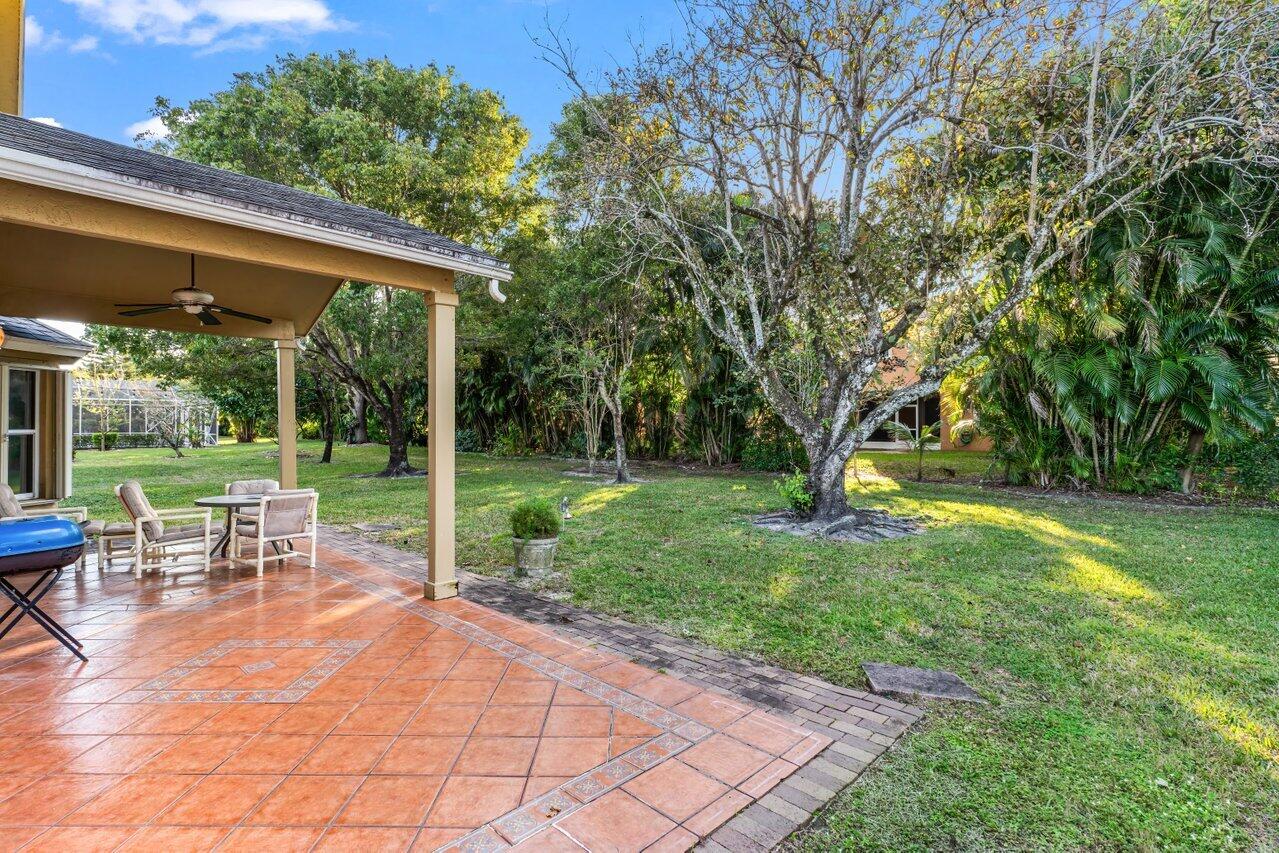 2224 Soundings Court Greenacres, FL 33413 - Photo 24 of 46 a view of backyard with table and chairs and a large tree