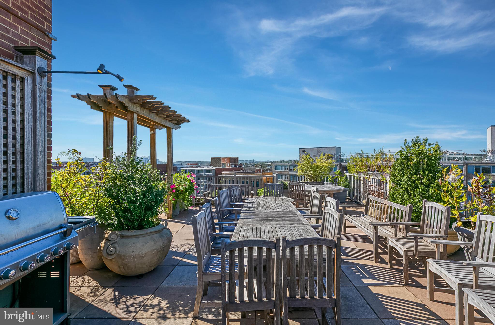 1301 20th Street Northwest, Unit 901 Washington, DC 20036 - Photo 23 of 26 a view of a roof deck with table and chairs potted plants with sky view