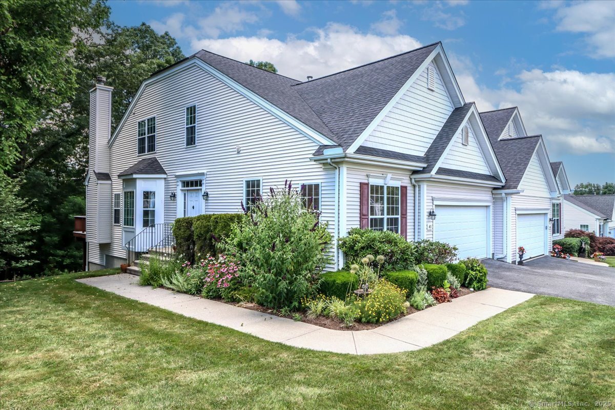a view of a house with a yard and potted plants