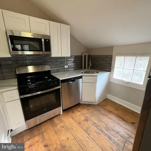a kitchen with stainless steel appliances a stove a microwave and a sink