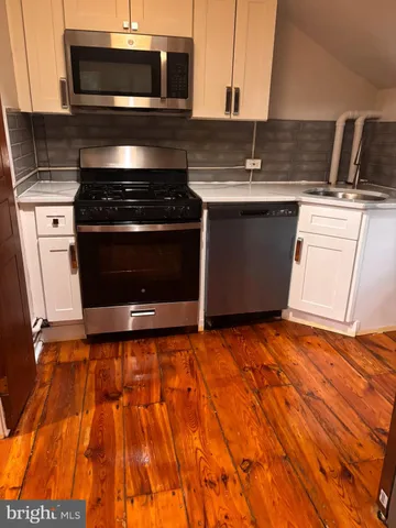 a kitchen with granite countertop a stove and a microwave