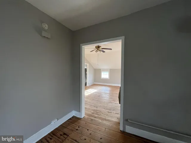 a view of empty room with wooden floor