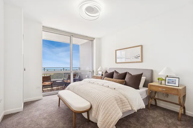 a bedroom with a bed and a lamp on dresser