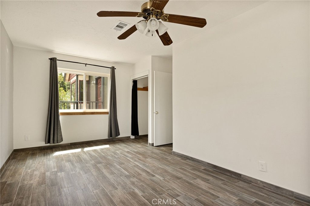 33159 Ridge Drive Running Springs, CA 92382 - Photo 15 of 24 a view of an empty room with wooden floor and a window