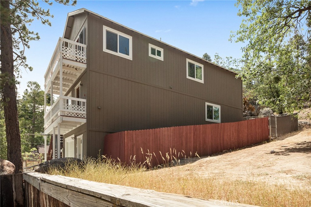 33159 Ridge Drive Running Springs, CA 92382 - Photo 3 of 24 a view of a house with a wooden fence